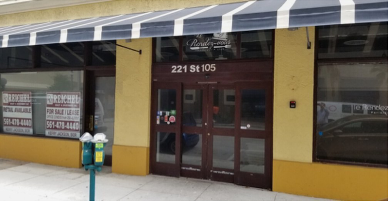 Storefront with striped awning and parking meters