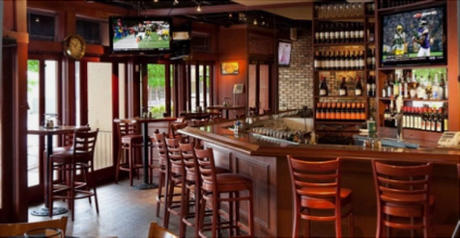 Empty bar with wooden furniture and TVs