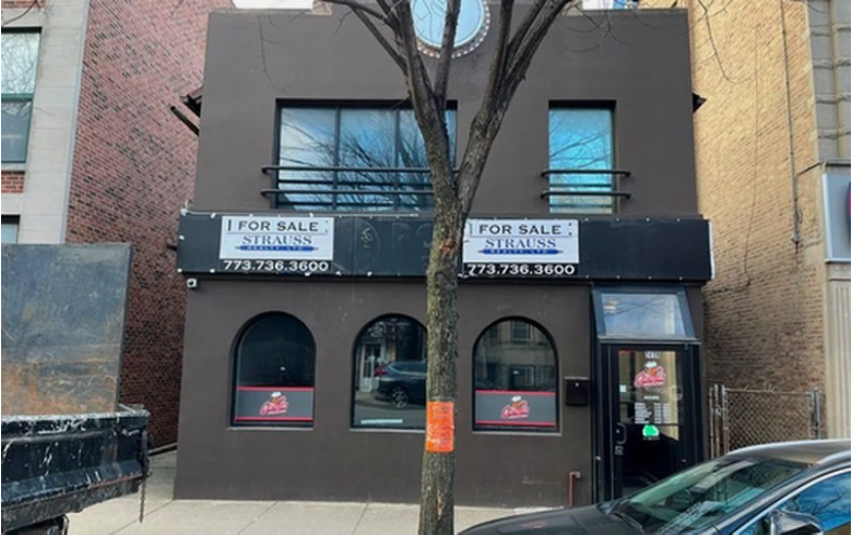 Two-story building with "For Sale" signs